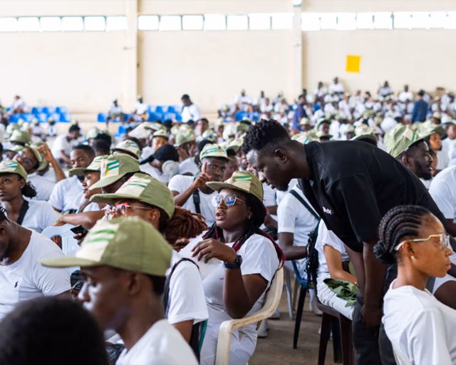 A Pody team member leans in to answer a corps member's question